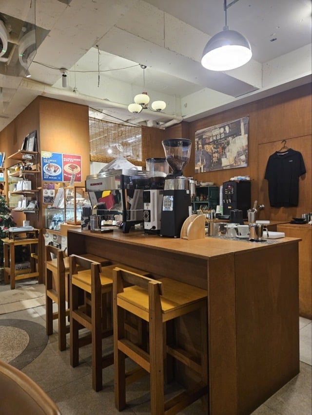 칠복상회로스터스 커피 바: 에스프레소 머신과 우드 카운터, 높은 나무 의자가 있는 공간