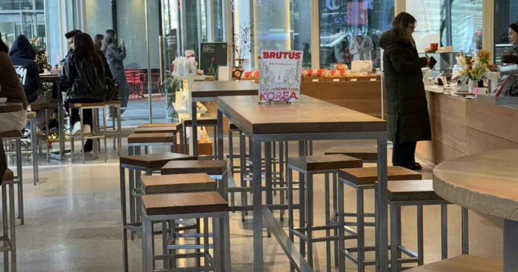 청계천 four B 카페 내부 인테리어 — 우드와 스테인리스가 조화를 이루는 테이블 배열과 밝은 분위기의 공간 디자인