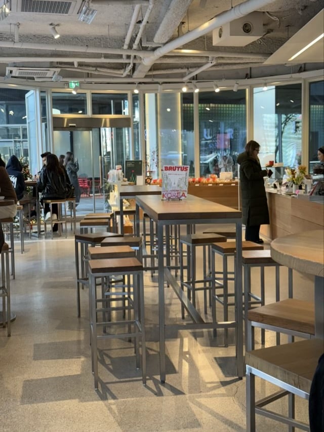 청계천 four B 인테리어 메인 공간 전경, 우드 테이블과 스테인리스 구조가 보이는 모습