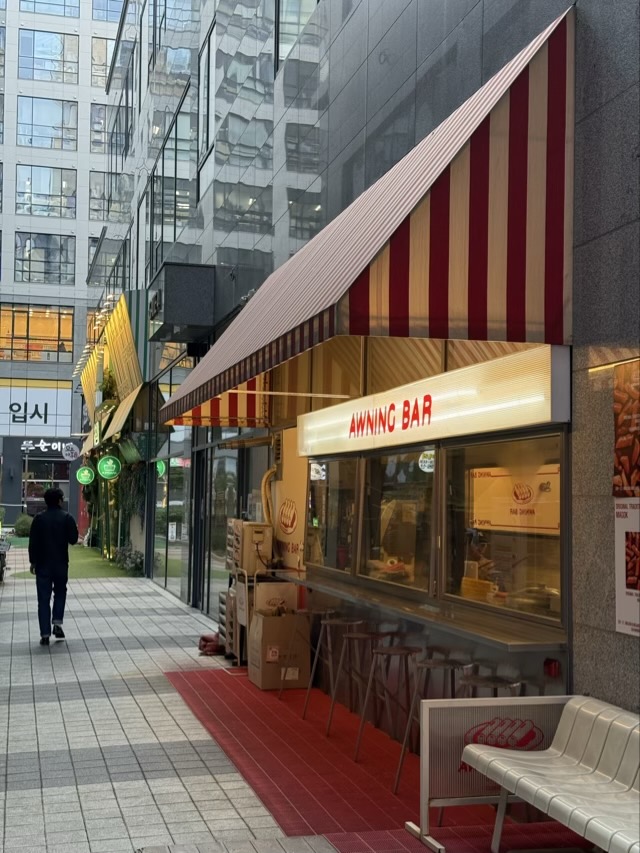 마곡 어닝바 인테리어 분석: 키치 레트로 인테리어로 공간을 극대화한 상업시설 인테리어 마곡 어닝바 외관. 스트라이프 어닝과 오픈 바 형태의 상업시설 인테리어