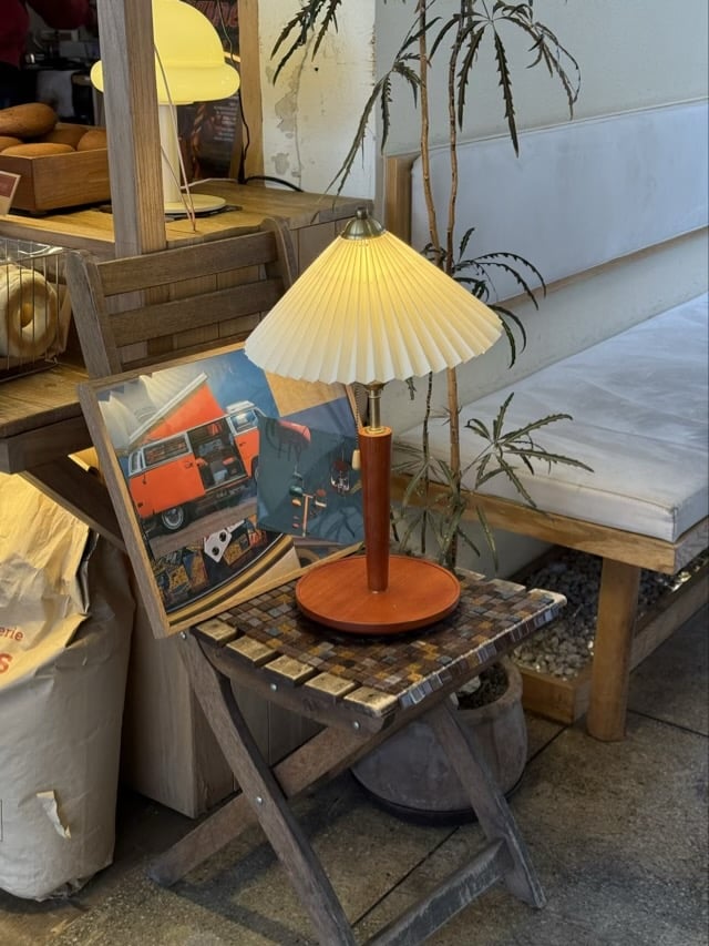 빈티지한 주름 갓 조명이 놓인 작은 우드 테이블과 식물, 수원 권선동 베이글 커피하우스의 소품 디테일.