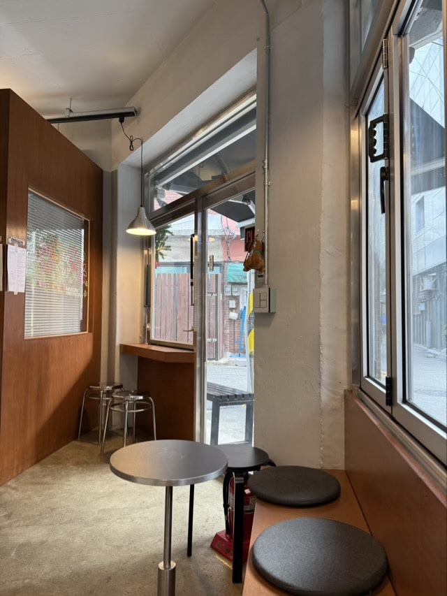 따뜻한 조명과 금속 스툴이 조화로운 안암 카페 인테리어 구석 좌석