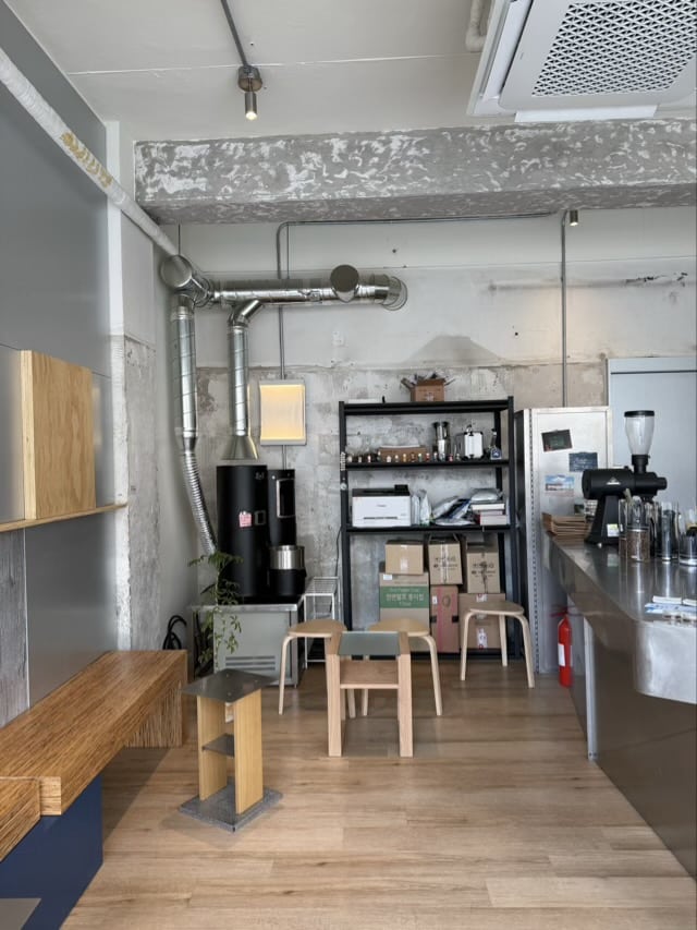 dprt 카페 내부의 로스팅 기계와 스테인리스 선반 수납 공간