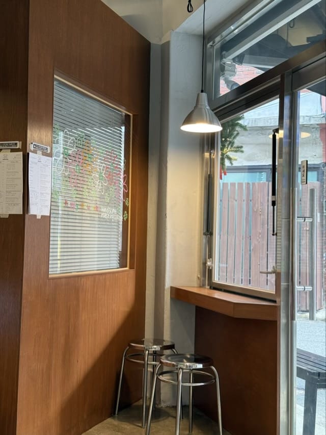 안암 핸섬로스팅카페 인테리어의 창가 좌석과 합판 벽면 디자인