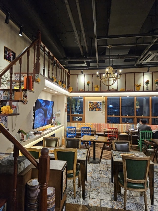 컬러풀한 의자와 앤틱 조명이 어우러진 슈가스컬의 식사 공간