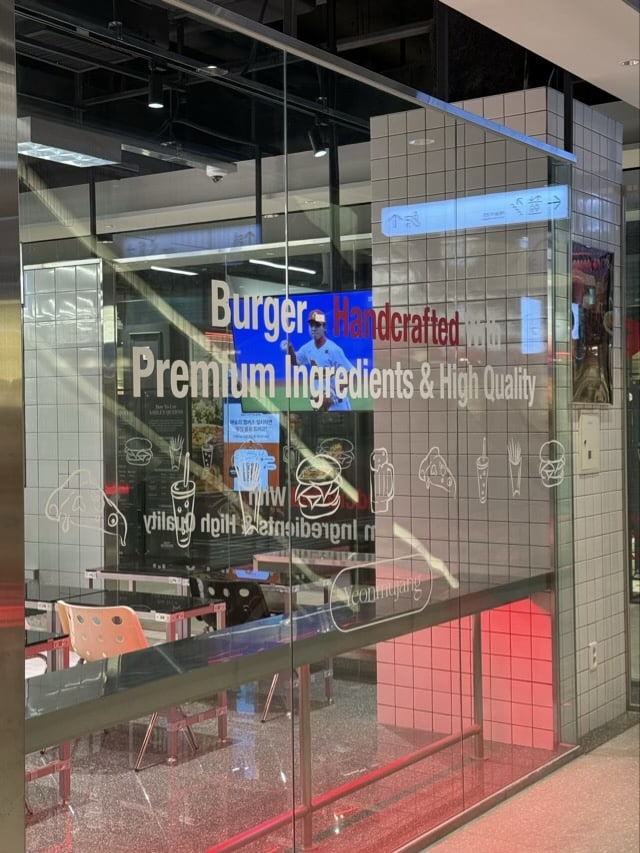 동대문 연무장 유리벽의 버거 및 피자 일러스트와 미래지향적 문구