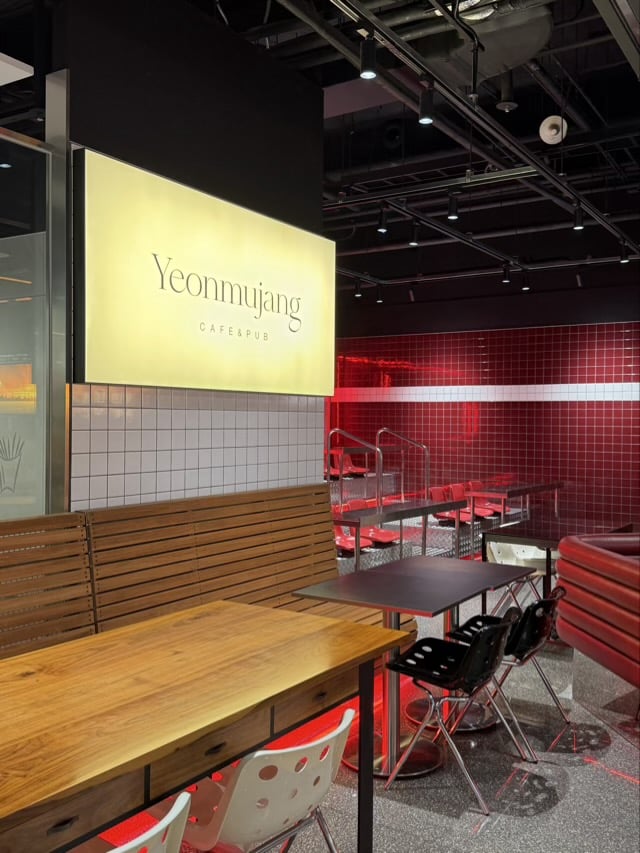 동대문 카페 연무장의 따뜻한 조명과 원목 테이블 좌석 배치