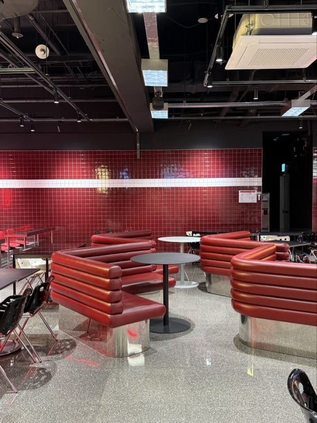 동대문 연무장 내부의 붉은 가죽 소파와 붉은 타일 벽면 인테리어